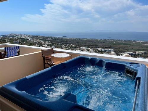 a hot tub on a balcony with a view of the ocean at Panorama Oia Apartments in Oia