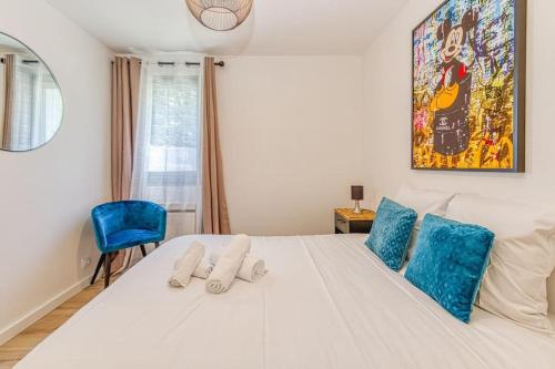 ein Schlafzimmer mit einem großen weißen Bett mit blauen Kissen in der Unterkunft Belles prestations, 3 ch, terrasse, wifi fibre in Grenoble