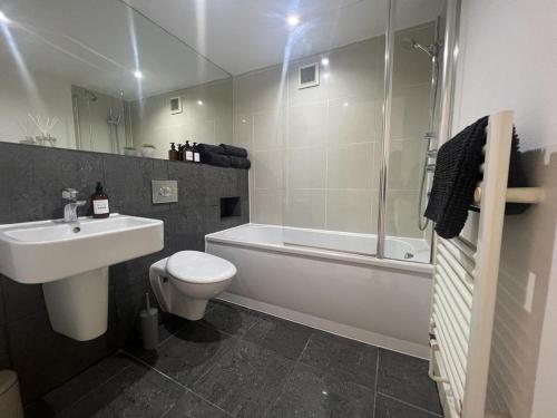 a bathroom with a sink and a toilet and a shower at Full Apartment! Brick Lane! in London
