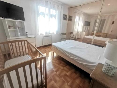 une chambre avec un grand lit blanc et deux chaises dans l'établissement Villa Cinsault, au Cap d'Agde