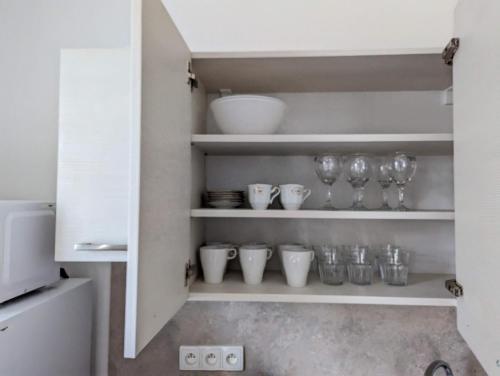 a cupboard with bowls and glasses on it at Restaurace a penzion Gansberg in Cotkytle