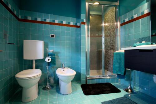 a blue tiled bathroom with a toilet and a shower at Bed & Brekfast da Kate Dreams and Colors in Foglizzo
