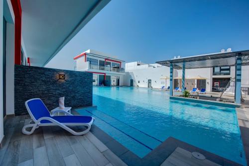 a blue lounge chair sitting on the edge of a swimming pool at KAY Homes in Ras al Khaimah
