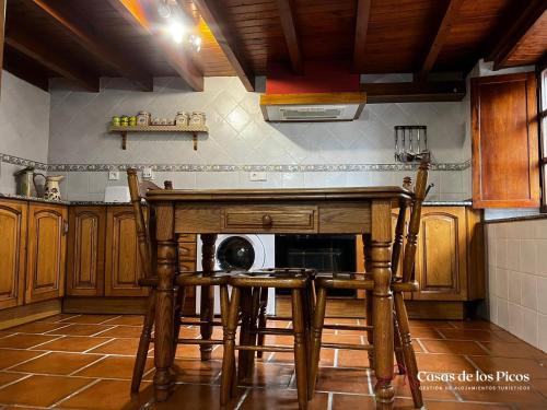Il comprend une cuisine équipée d'une table, de chaises et d'un four micro-ondes. dans l'établissement Vivienda vacacional El Cau - Casas de Los Picos, à Ruenes