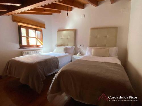 - une chambre avec 2 lits et une fenêtre dans l'établissement Vivienda vacacional El Cau - Casas de Los Picos, à Ruenes