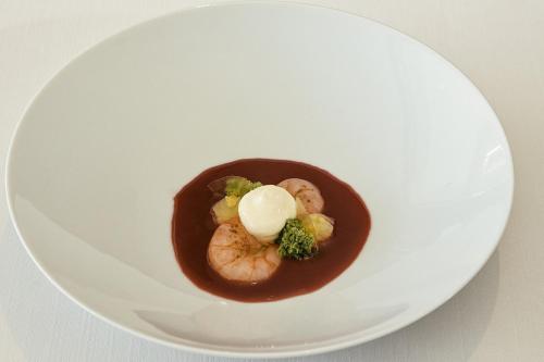 a white plate with a dish of food with sauce at Hotel Emporium - Adults Only in Castelló d'Empúries