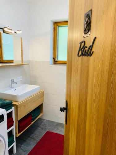 a bathroom with a sink and a door with the word stud at Ferienhaus Lemsitz 34 in Lemsitz