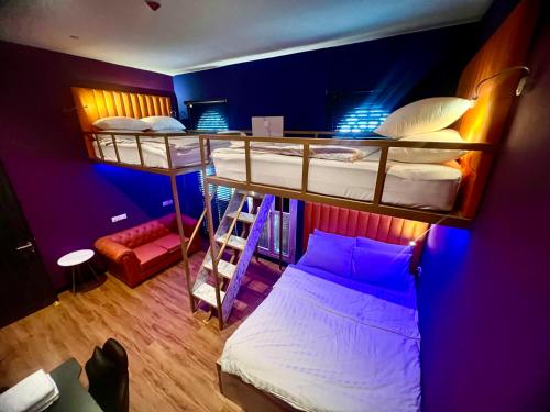 a room with three bunk beds with a ladder at Arena eSports @ Orchard in Singapore