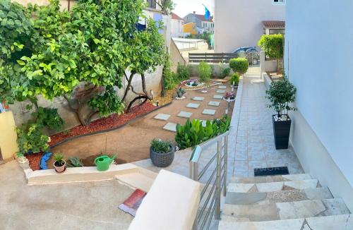 a garden with potted plants on the stairs of a house at LuMar Holidays and Apartments in Preko