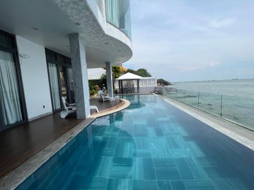 a swimming pool with a view of the ocean at Nancy Tran Grand Strip Vung Tau Villa 9 in Vung Tau