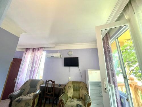 a room with a table and chairs and a television at HOTEL - SHORENA in Ureki