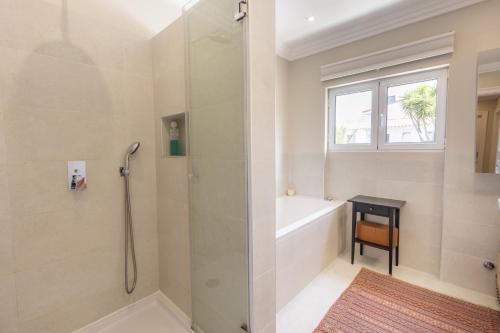 un bagno con doccia con porta in vetro di Estoril Contemporary Garden Villa by CadenzaLux a Cascais