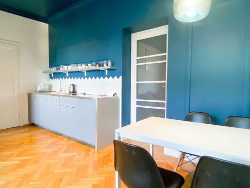 a kitchen with blue walls and a white table and chairs at Aesthetic Apartment Krakow-Center in Krakow