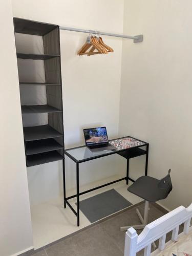 a desk with a laptop on it next to a shelf at Tranquil sea view villa in Argostoli