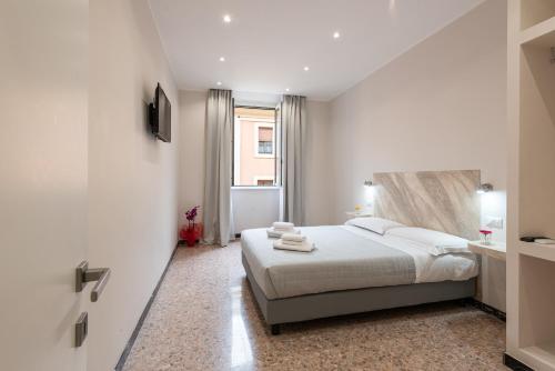 a white bedroom with a bed and a window at Ancient Rome Apartment in Rome