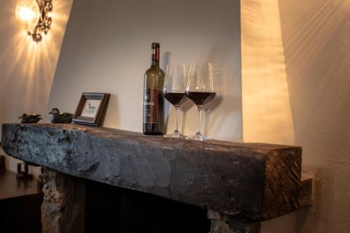 two glasses of wine sitting on a stone fireplace at Il Carisma in Pitigliano