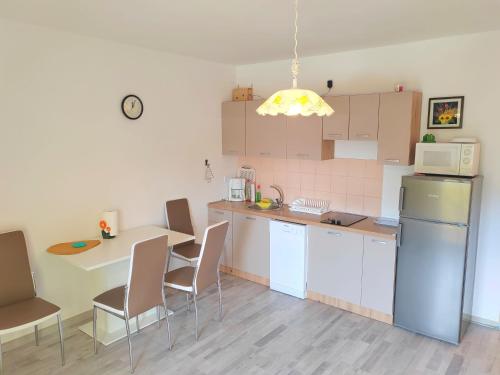 a kitchen with a table and chairs and a microwave at Apartment Zvonko in Stara Novalja