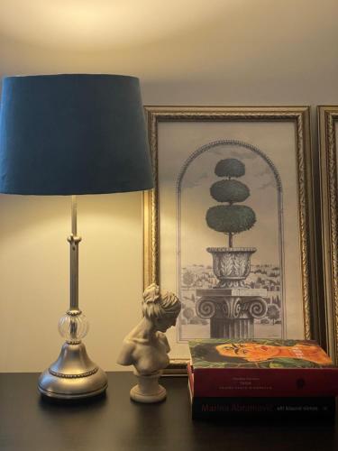 a lamp sitting on a table next to a book at Mėta House in Merkinė