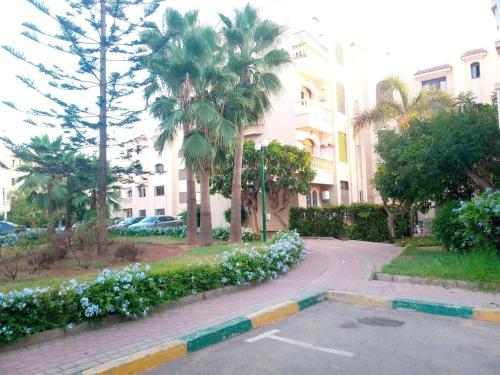 a street in front of a building with palm trees at Mohammedia in Mohammedia
