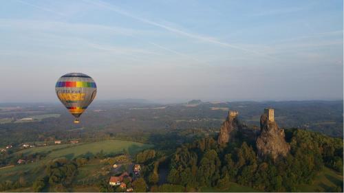 a hot air balloon flying over the mountains at Elitní wellness penzion U Dvou jedlí v srdci Českého ráje in Turnov