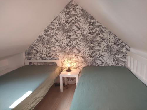 2 Einzelbetten in einem Zimmer mit einer Wand in der Unterkunft Ref 095 - Appartement pour quatre proche port Crouesty in Arzon