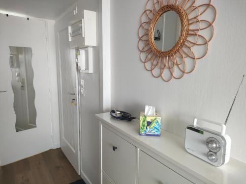 ein weißes Badezimmer mit einem Spiegel an der Wand und einer Theke in der Unterkunft Ref 095 - Appartement pour quatre proche port Crouesty in Arzon