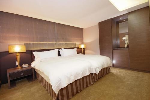 a hotel room with a large bed and a mirror at The Metro Hotel - Taipei Branch in Taipei