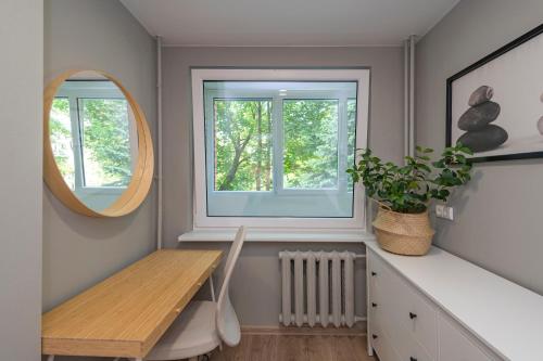 ein Esszimmer mit einem Tisch und einem Fenster in der Unterkunft Convenient apartment with balcony by Polo Apartments in Kaunas