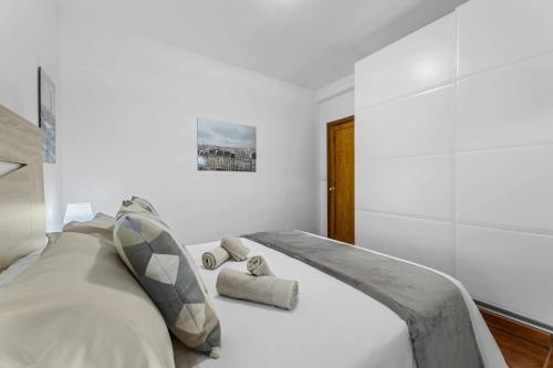 a white bedroom with a large bed with pillows at Holyhome mills 1113 in Costa Teguise