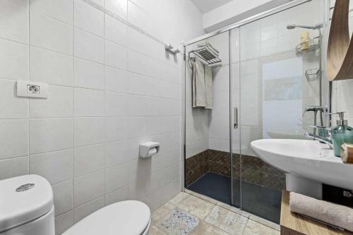 a bathroom with a toilet and a sink and a shower at Holyhome mills 1113 in Costa Teguise