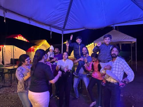 a group of people standing under a blue umbrella at Crown Bliss - Riverside Luxury Paradise in Kasol
