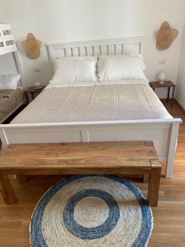 a large bed with a wooden table in a bedroom at APulia casa e cucina in Trani