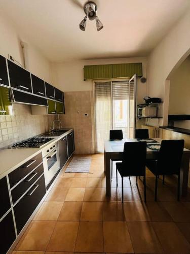 a kitchen with a table and chairs and a dining room at grazioso bilocale in Rimini