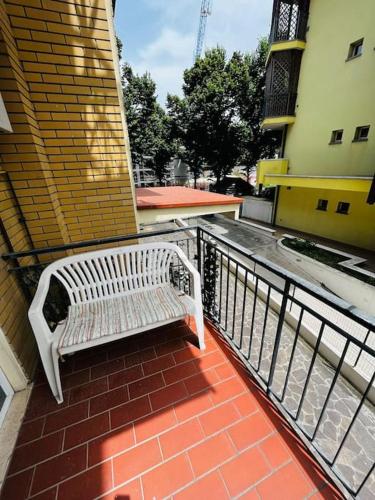 una panchina bianca seduta su un balcone di un edificio di grazioso bilocale a Rimini
