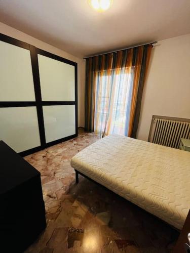 a bedroom with a bed and a large window at grazioso bilocale in Rimini