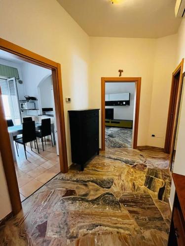 un soggiorno con pavimento in pietra e una sala da pranzo. di grazioso bilocale a Rimini
