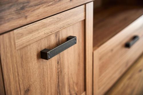 a close up of a wooden drawer with a black handle at Symphony City Square Aparthotel in Wrocław
