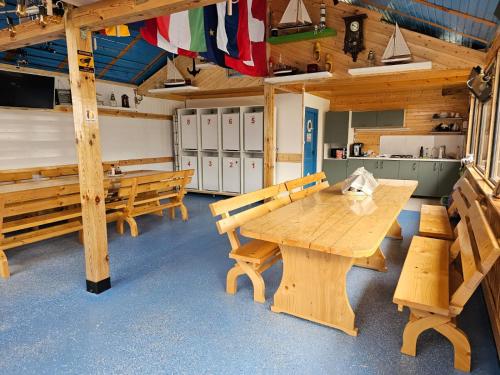 スリナにあるCasuta Noastra - Sulinaの木製テーブルとベンチ付きの広い客室です。