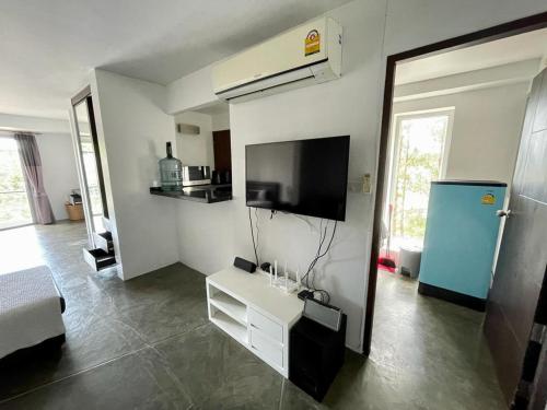 uma sala de estar com uma televisão e uma mesa branca em Spacious Apartment by the Sea em Bangrak Beach