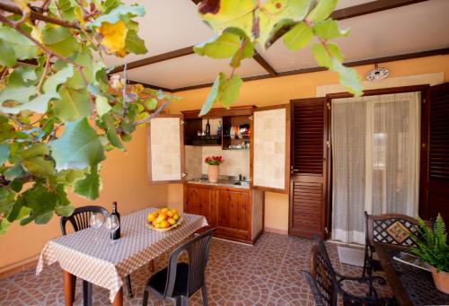 a dining room with a table and a kitchen at Sikania Suite in Pozzallo