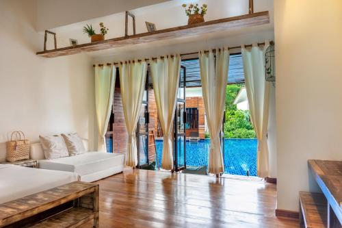 ein Wohnzimmer mit einem weißen Sofa und großen Fenstern in der Unterkunft Wendy the Pool Resort @ Koh Kood in Ko Kood