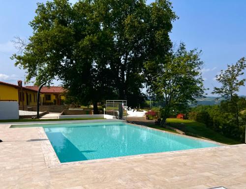 ein Pool vor einem Haus mit einem Baum in der Unterkunft Colle Del Sole in Lastra a Signa