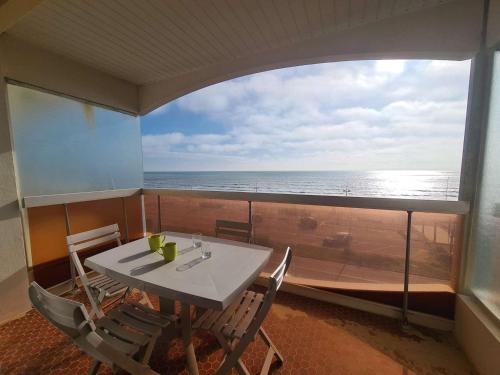 une table et des chaises dans une pièce avec vue sur l'océan dans l'établissement Appartement Face Mer, 3 Pièces, 4 Couchages avec Balcon, Parking Privé, 2 Étoiles - Saint-Jean-de-Monts - FR-1-224C-113, à Saint-Jean-de-Monts