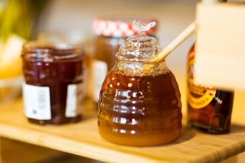 a bottle of honey on a shelf with other jars of honey at ibis budget Paris Porte de Vanves in Vanves