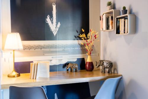 a desk with two elephants and a vase on it at ibis budget Paris Porte de Vanves in Vanves