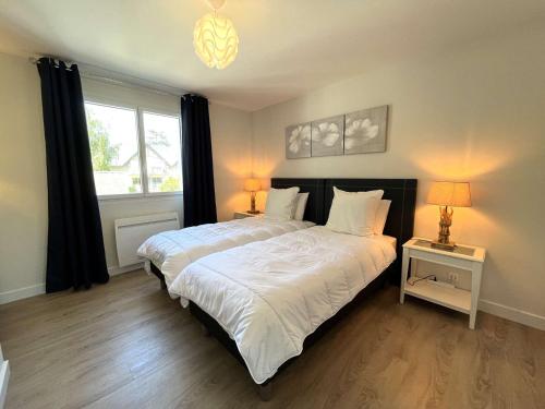 a bedroom with a large bed and a window at Bénodet: appartement avec terrasse, proche plage, thalasso et restaurants - FR-1-481-147 in Bénodet