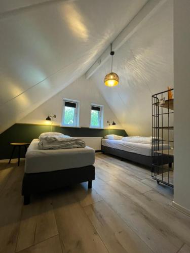 a bedroom with two beds and a table in a room at Luxe Vakantiehuis Vosje op de Veluwe Nunspeet in Nunspeet