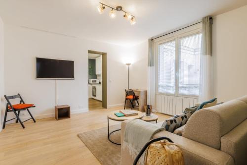 un salon avec un canapé et une télévision dans l'établissement Authentic studio - 2P - Eiffel Tower, à Paris