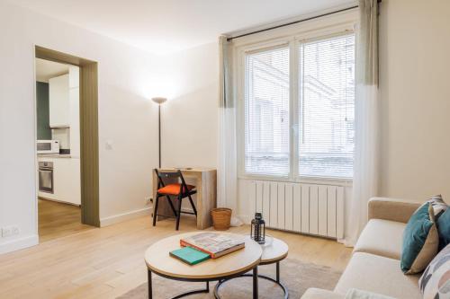 un salon avec un canapé et une table dans l'établissement Authentic studio - 2P - Eiffel Tower, à Paris