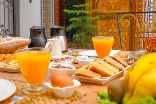 a table with eggs and bread and two glasses of orange juice at Riad Sahraui in Fès